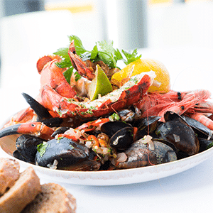 Langosta servida con un ceviche de mariscos